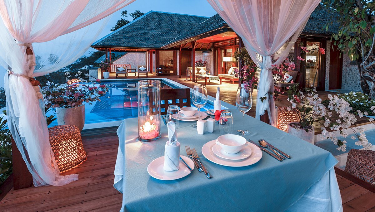 A table set for two pool side at the villa for a private dining occasion.